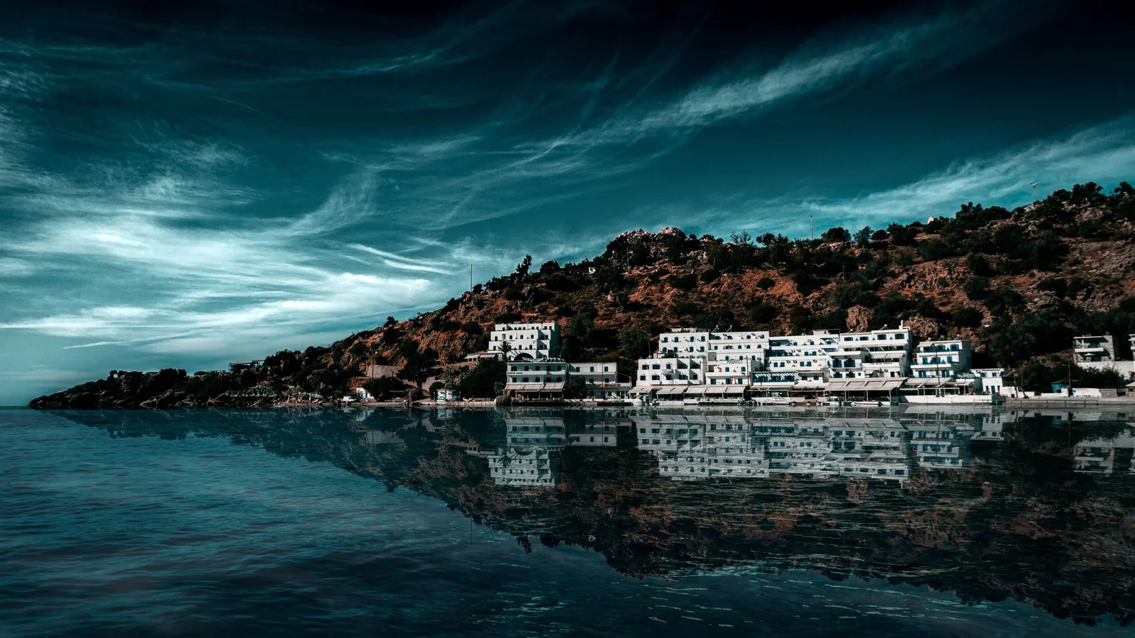 Le front de mer de Loutro et ses maisons blanches reflétés dans la mer calme, au sud de la Crète