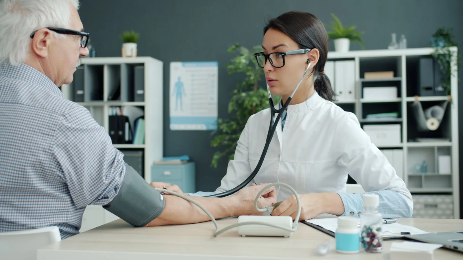Médecin prenant la tension d'un patient senior lors d'une consultation