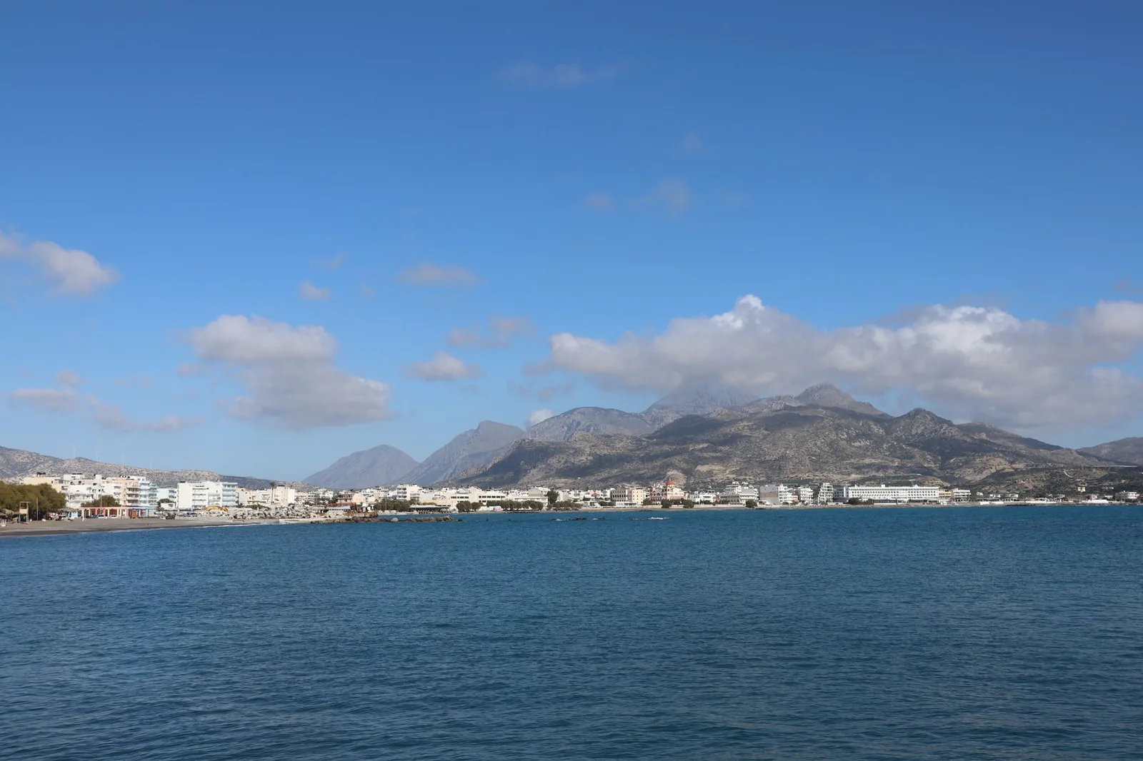 Nuages accrochés aux montagnes derrière une ville côtière de Crète