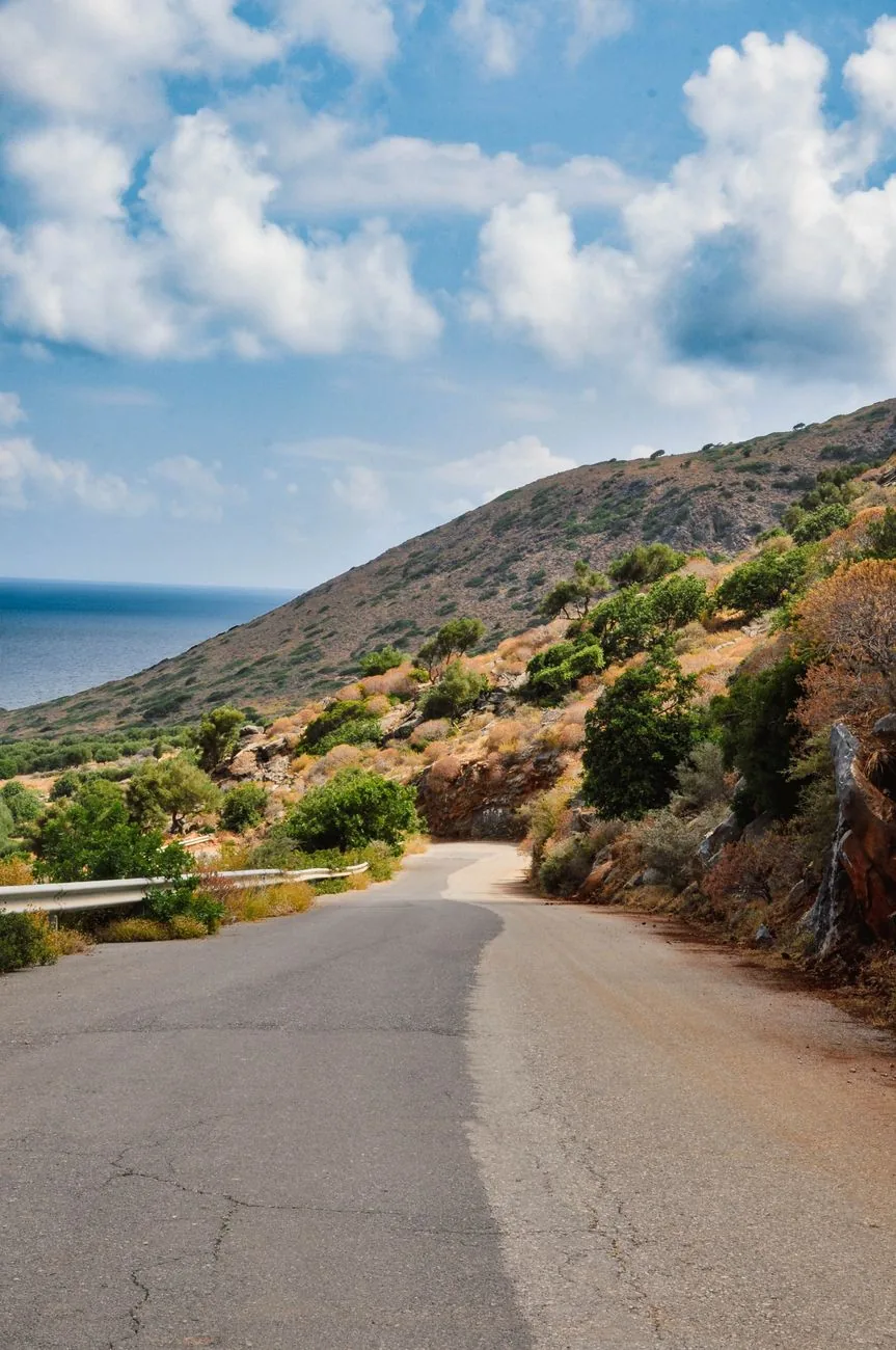 Une route sinueuse descendant vers la mer, sur la côte de la Crète