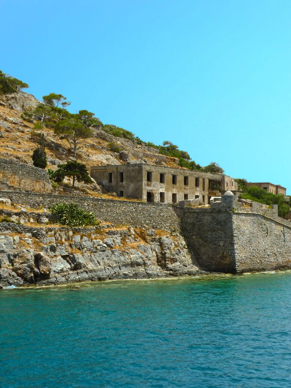 Bâtiments en ruine du village des lépreux au bord de l'eau sur l'île de Spinalonga