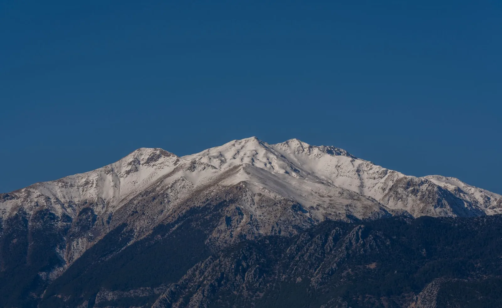 Sommet de montagne enneigé sous un ciel d'hiver bleu profond
