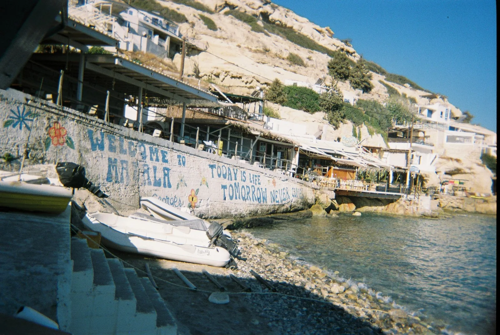 Le mur peint « Welcome to Matala » et le front de mer du village, en Crète